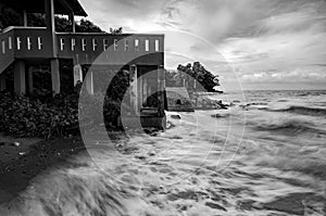 Black and white image wave hitting the coastline