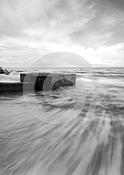 Black and white image wave hitting the coastline