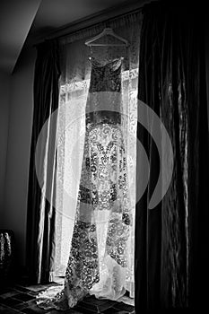 BLACK AND WHITE IMAGE of a Wedding dress prepared for the bride. Wedding dress. White floral lace from a wedding dress. Details.