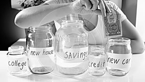 Black and white image of young woman saving money for buying new car