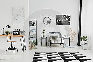Black and white interior design of bright kid`s bedroom with laptop on desk