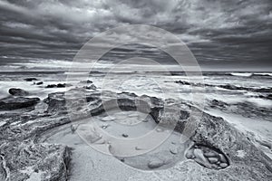 Black and white landscape of ocean rocks and clouds artistic con