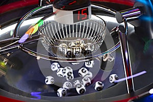 Black and white lottery balls in a rotating bingo machine. Number 15