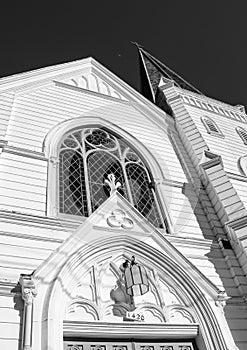 Black and white, low angle view of an ornate church with the sky and moon in the background.