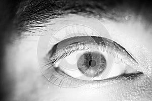 Black and white macro image with the brown eye of a man