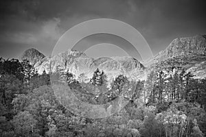 Black and white Majestic landscape image of stunning Autumn sunset light across Langdale Pikes looking from Holme Fell in Lake