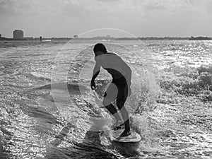 Black and white of male wake surfing at sea
