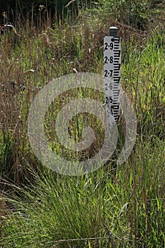 A black and white metal water level measuring gauge in a flood prone area of rural Australia