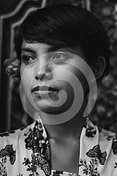 Black and white monochrome retro portrait of a beautiful short hair Asian Balinese woman wearing floral cloth vintage style and