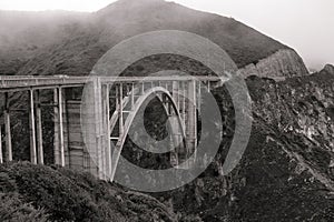 A black and white moody shot of Bixby Bridge on the Big Sur coastal highway