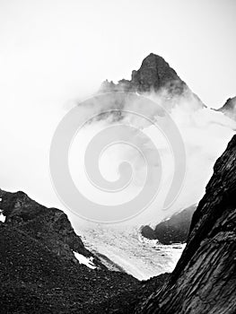Black and white Mountains in cloud above a glacier