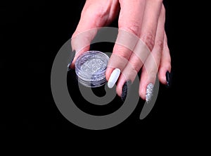 Black, white Nail art manicure. Holiday style bright Manicure with sparkles. Bottle of Nail Polish. Beauty hands