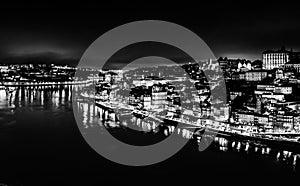 Black and white night cityscape panorama of Porto old town and river Douro banks skyline with water reflections in Porto, Portugal