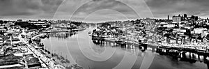 Black and white night cityscape panorama skyline of Porto old town, Luis I Bridge and river Douro banks with reflections