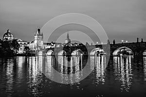 Black and white night landscape of Charles Bridge and its reflactions in the Vltava river in Prague, Czech Republic