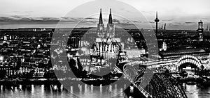 Black and white night landscape of the gothic Cologne cathedral, Hohenzollern Bridge and the River Rhine in Cologne, Germany