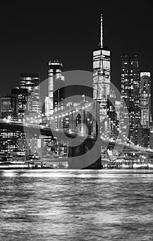 Black and white night view of Brooklyn Bridge and Manhattan waterfront, New York City, USA