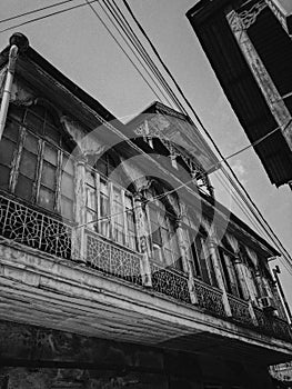 Black and white old antique balcony of a wooden european house. European old architecture. Vertical photo