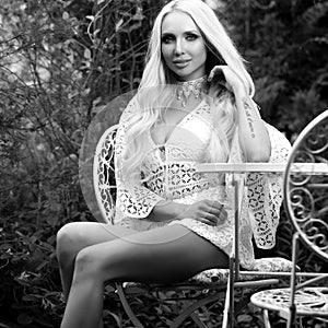 Black-white outdoor portrait of beautiful young blond woman in stylish dress