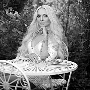 Black-white outdoor portrait of beautiful young blond woman in stylish dress