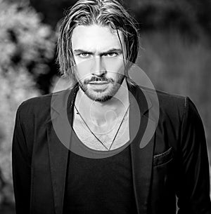 Black-white outdoor portrait of elegant long hair handsome man