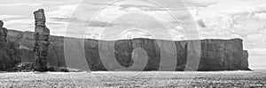 Black and white panorama of Old Man of Hoy, a tall sandstone stack at the coast between Stromness and Scrabster at Orknay