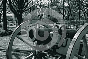 Black and white photo, an ancient cannon that shoots nuclei stands on the seashore