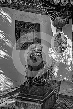 Black and white photo of antique statue of lion in oriental style. Sculptural details of Yu Yuan Garden of Shanghai old city