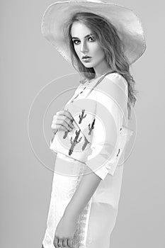 Black and white photo of a beautiful young woman in summer clothes in the studio