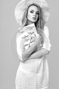 Black and white photo of a beautiful young woman in summer clothes in the studio