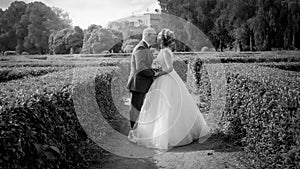 Black and white photo of bride and groom kissing first time on wedding ceremony at park