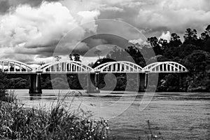 a black and white photo of a bridge over a river