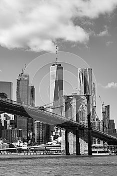 Black and White Photo of the Brooklyn Bridge with an American Flag over the East River with the Lower Manhattan New York City Skyl