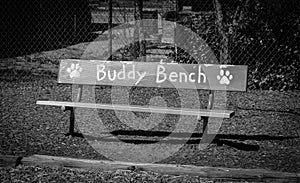 Black and white photo of a Buddy Bench at an elementary school