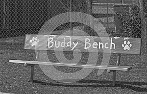 Black and white photo of a Buddy Bench at an elementary school