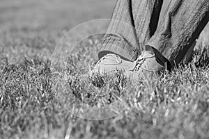 Black and white photo of businessman foot on the grass