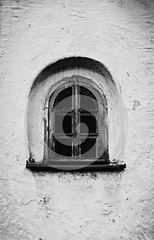 The black-white photo captures a small, vintage window with wooden frames set in a medieval building. History and nostalgia. The