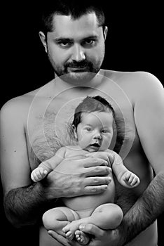 Black and white photo. Dad holding in his hands little newborn baby. Father's love