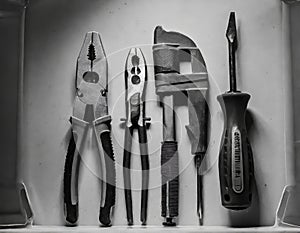 Black and white photo of DIY tools, hammer, pliers, screwdriver for handymen. Manual work