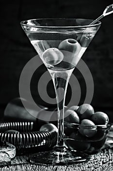 Black and white photo. Dry martini, vermouth with olives, wooden