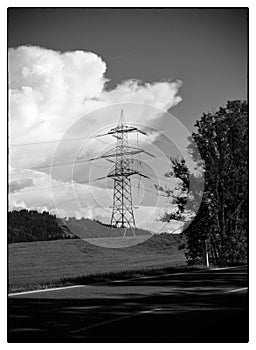 Black and white photo of Electricity tower in sunny day on the cloudy beautiful sky