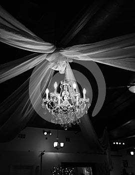 Black and white photo of elegant chandelier and drapes