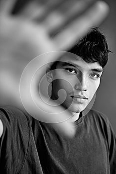 Black and white photo of handsome man showing stop sign