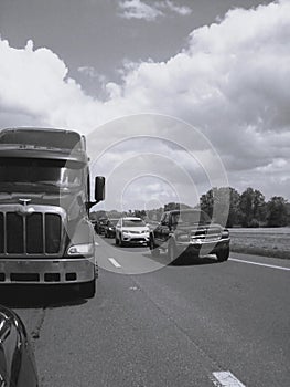 Black and white photo of highway traffic, cars and truck