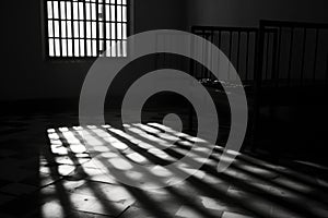 A black and white photo of a jail cell. Perfect for illustrating crime and punishment or prison-related concepts