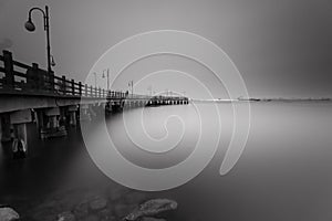 Black and white photo of jetty bridge on Ancol beach, Jakarta