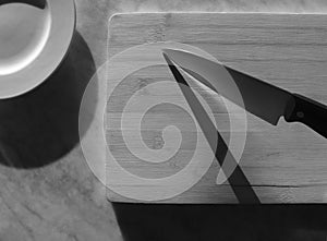 black & white photo of knife on a wooden tray over a marble table