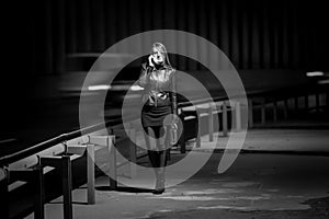 Black and white photo of lwoman walking at highway at night