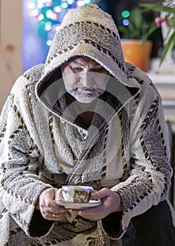 Black and white photo of a man in a robe drinking tea after a bath, portrait of a man