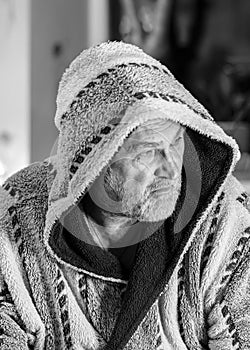 Black and white photo of a man in a robe drinking tea after a bath, portrait of a man